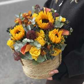 Композиция в сумке "Тональность" из подсолнухов, калл, ягод вибирнума, лимонных роз, скиммии и орхидеи в Озерах